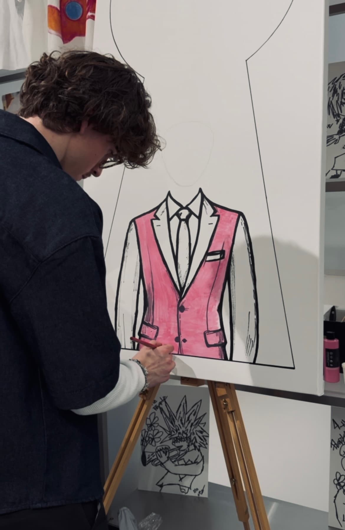 Th3rd Door painting a faceless pink suit on canvas